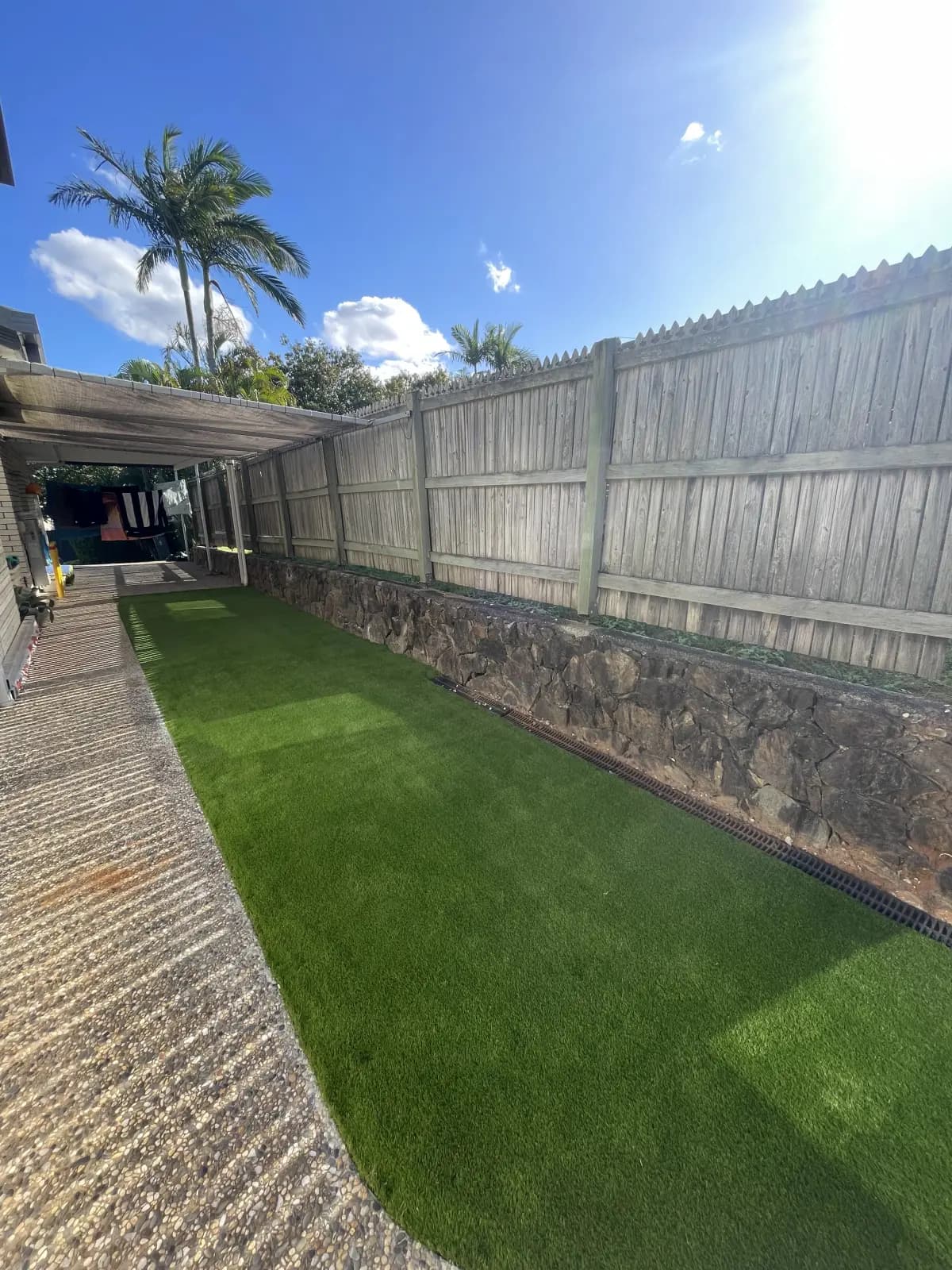 Backyard with artificial turf beside a paved path