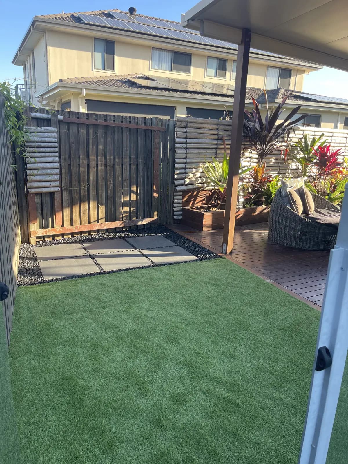 Courtyard with artificial turf, pavers, and garden edging